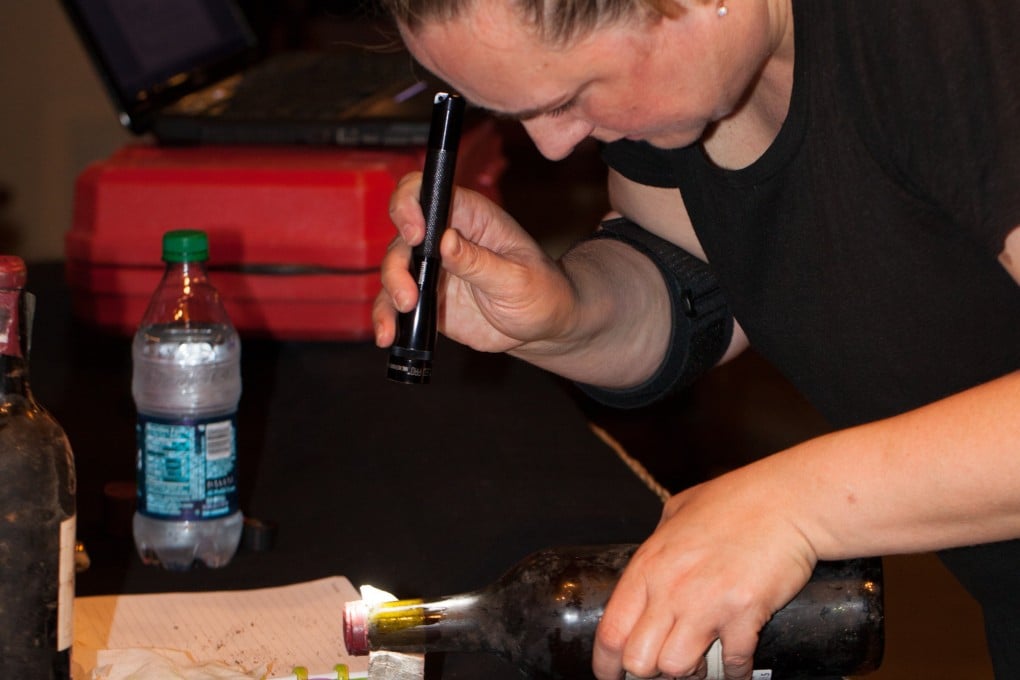 Expert wine fraud detector Maureen Downey examines a bottle of wine. She will hold authentication workshops in Hong Kong in March. Photo: Maureen Downey