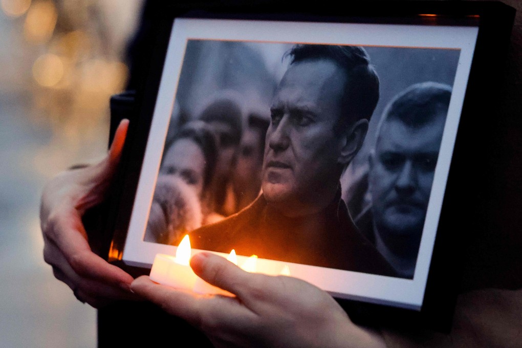 A protester holds candles and a picture of the late opposition leader Alexei Navalny, whose funeral service will be held at a church in southern Moscow on March 1. Photo: AFP