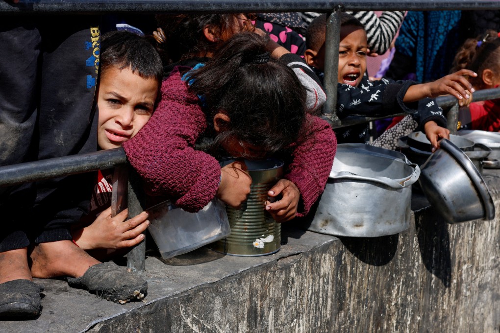 Palestinian children wait to receive food cooked by a charity kitchen on February 20, as the United Nations Security Council fails to pass a resolution calling for a ceasefire. Photo: Reuters
