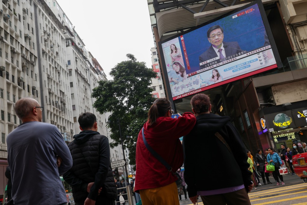 People watch a press conference broadcast with Chief Executive John Lee on a large screen at Causeway Bay. Photo: Jelly Tse