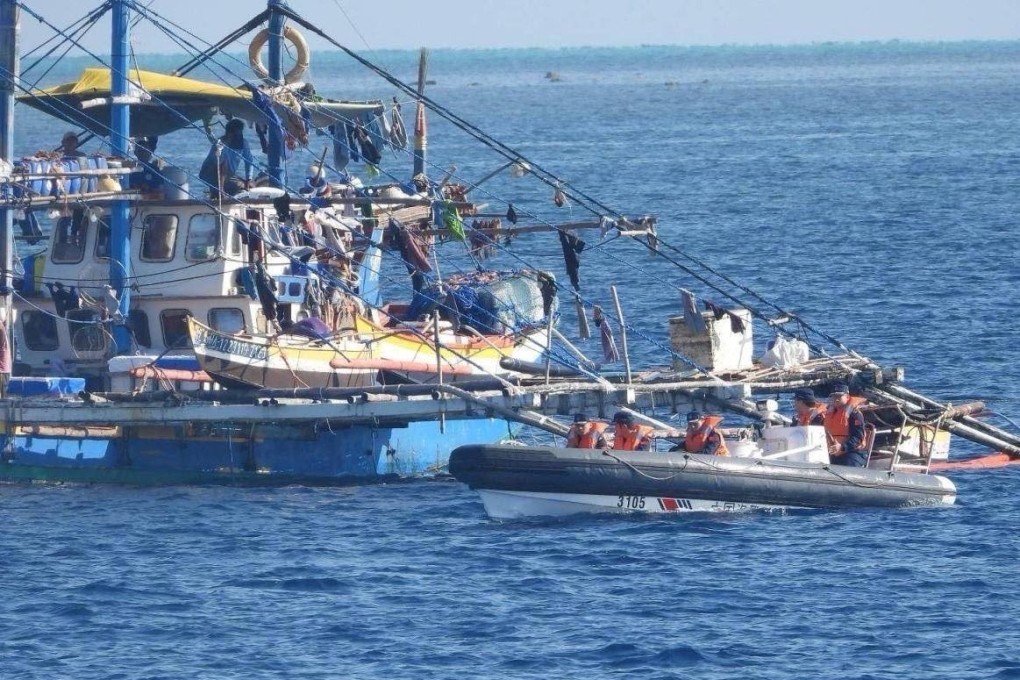 China Coast Guard personnel onboard a rigid-hulled inflatable boat, right, are seen shadowing a Philippine fishing boat near the Scarborough Shoal on February 22. Photo: PCG/AFP
