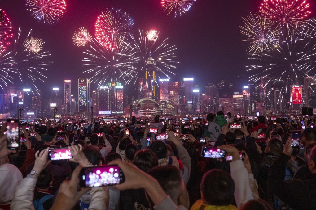 A crowd watches fireworks lighting up over Victoria Harbour on the second day of Lunar New Year on February 11. Photo: AP