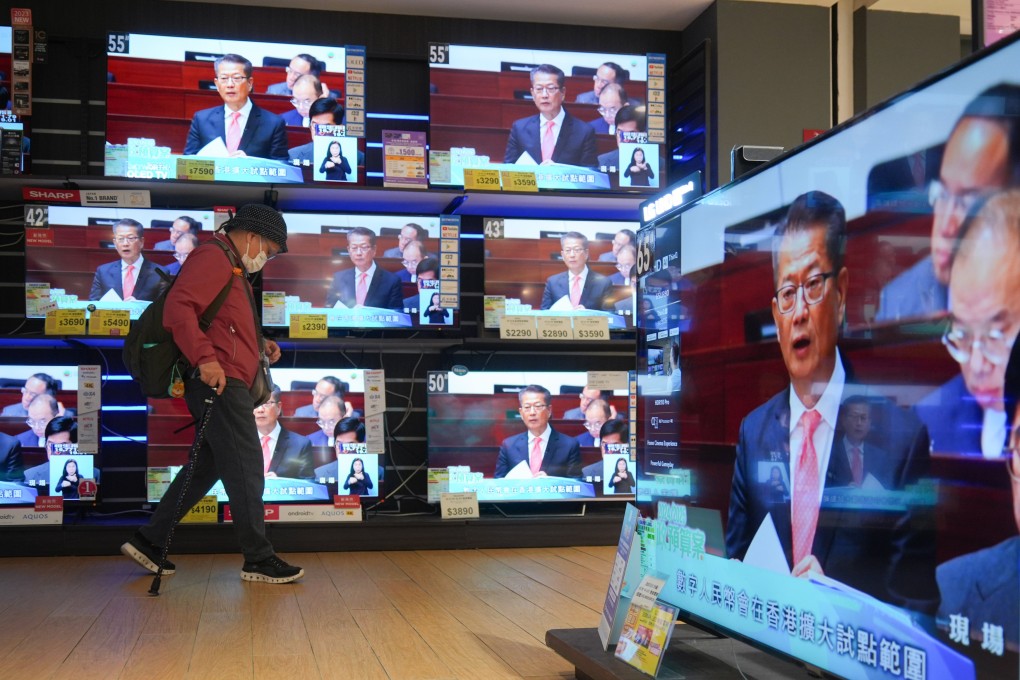 Televisions in an electronics shop show Financial Secretary Paul Chan delivering his budget address on Wednesday. Photo: Eugene Lee