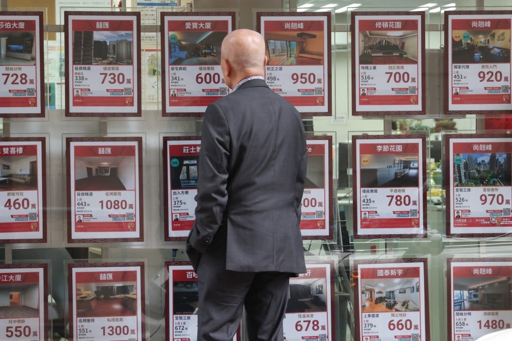 A man looks at property prices displayed in the shop window of an agency in Wan Chai on February 27, a day before the financial secretary scrapped all property market cooling measures. Photo: Jelly Tse