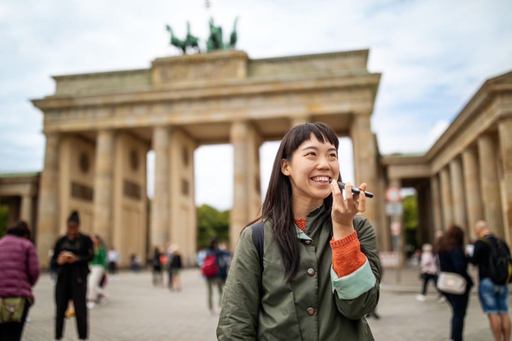 A woman uses an AI-powered translation app on her smartphone while on holiday. As the technology becomes evermore advanced, linguists weigh in on whether it will replace the need to learn foreign languages. Photo: Getty Images