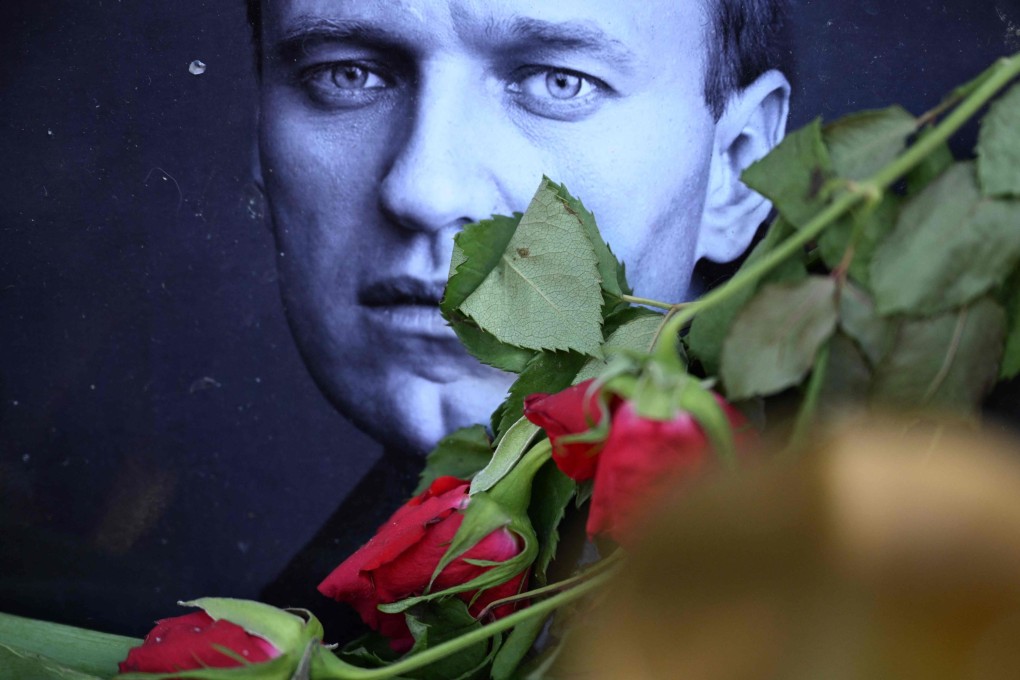Roses are laid at a picture of late Russian opposition leader Alexei Navalny at a makeshift memorial in Frankfurt am Main, Germany, Thursday. Photo: AFP