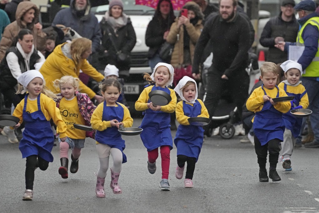 Schoolchildren take part in the children’s races prior to the annual Pancake Race in the town of Olney. Photo: AP