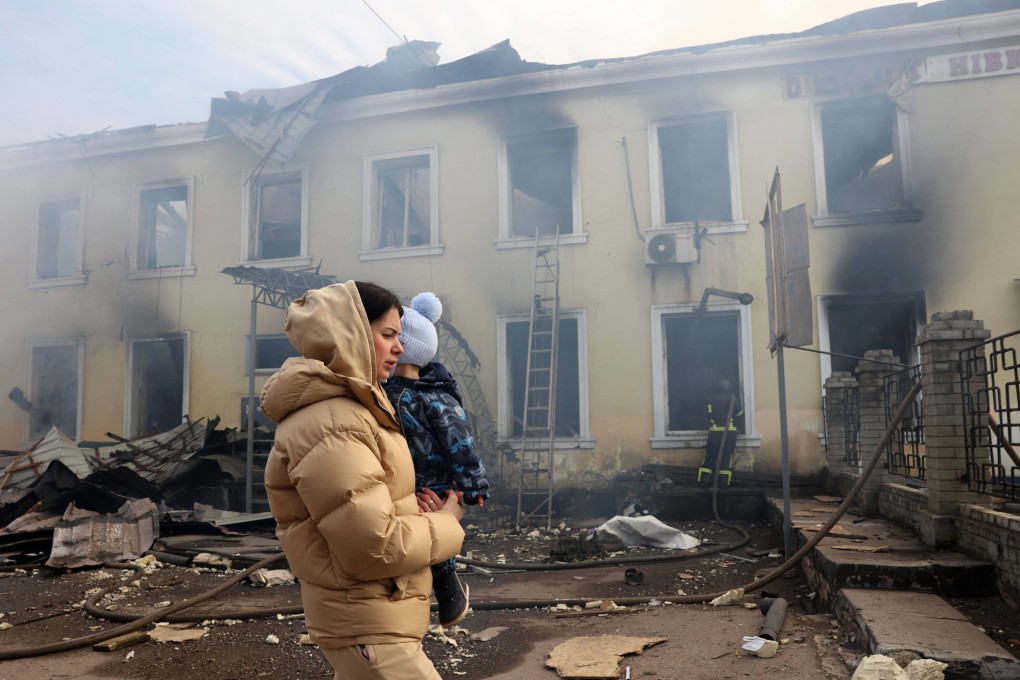 A woman and her child walk past a railway station hit in a Russian missile attack in Konstyantynivka in the Donetsk region of Ukraine on February 25. Photo: AFP