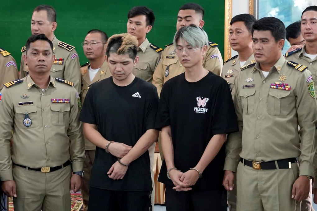 Taiwanese influencers Chen Neng Chuan (centre left) and  Lu Tsu-hsien (centre right) stand with Cambodian police during a press conference in Preah Sihanouk province on February 15. Photo: Preah Sihanouk Provincial Administration/AFP