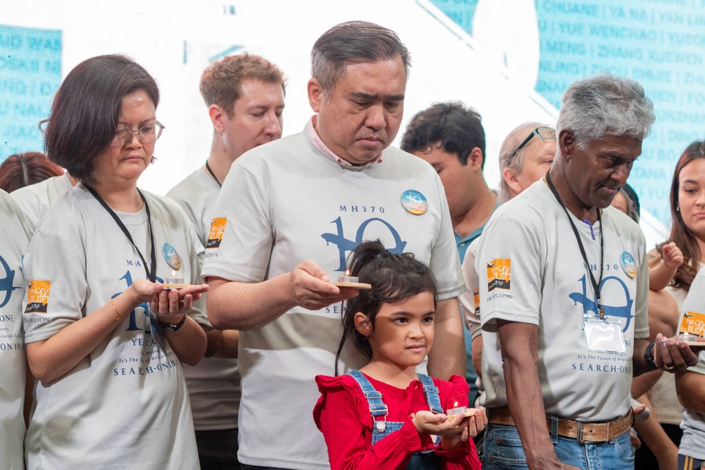 Malaysian Transport Minister Anthony Loke, centre, joins the relatives of missing MH370 passengers in a candlelight vigil on March 3. Photo: Hadi Azmi