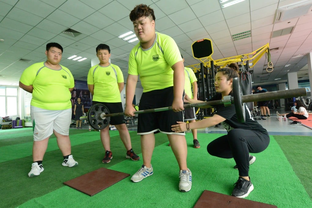 Obese Chinese boys exercise with a coach at a summer camp in Zhengzhou, Henan, in July 2017. Summer camps have sprouted up across the country in recent years to help fat children lose weight. Photo: Visual China Group via Getty Images