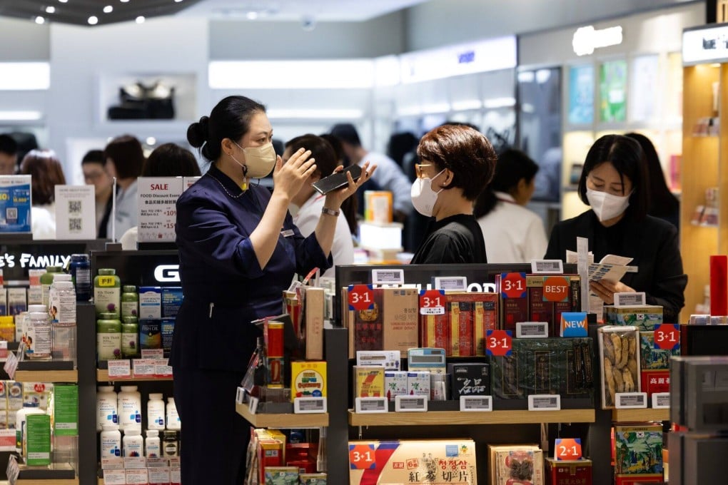 Chinese tourists look at cosmetic products in Seoul. Photo: Bloomberg