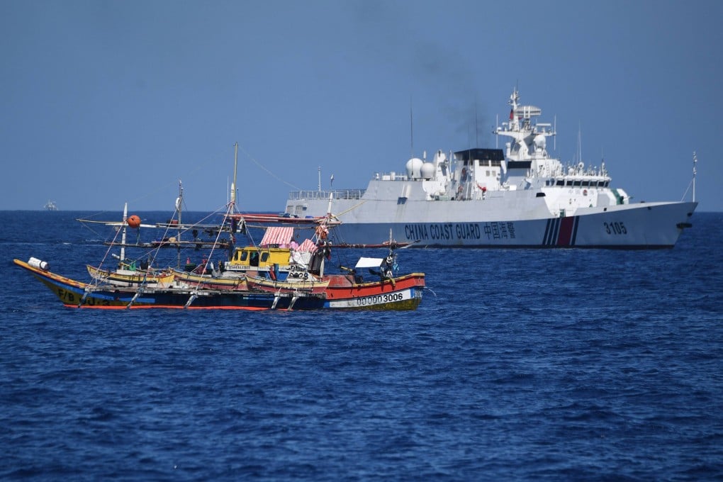 A Chinese coast guard ship (right) sails past a Philippine fishing boat near the China-controlled Scarborough Shoal, in disputed waters of the South China Sea in February. Photo: AFP