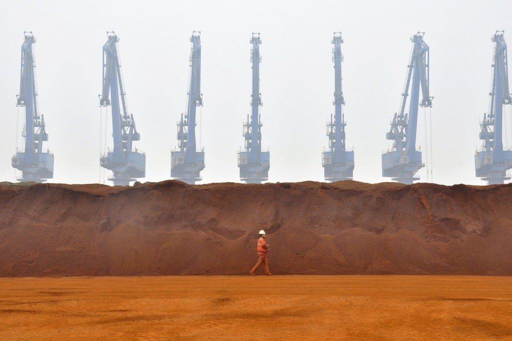 A worker walks past a pile of iron ore from Australia at a port in Tianjin municipality. Photo: Reuters