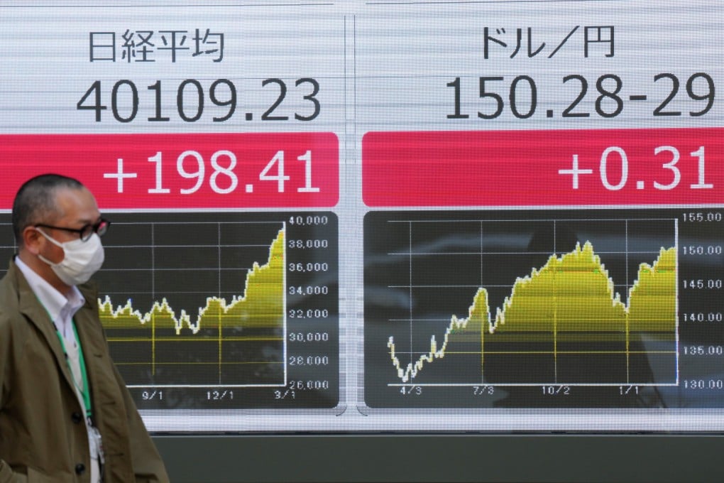 A man walks past a display showing the Nikkei Stock Average breaching the 40,000 level for the first time on March 4. Photo: EPA-EFE