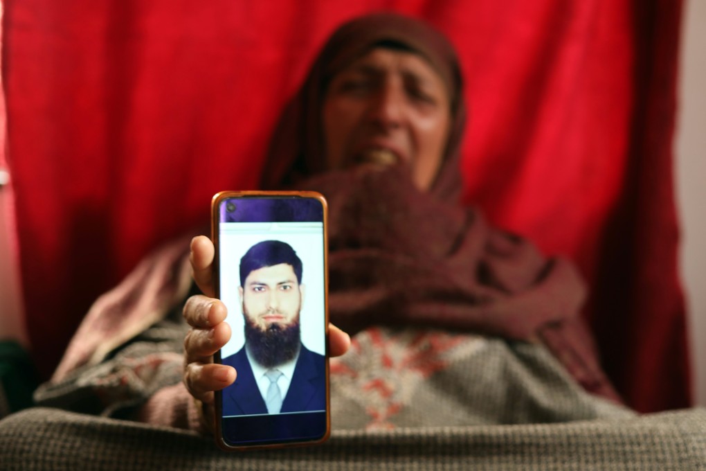 The mother of Aazad Yusuf Kumar, from a village in Indian Kashmir, shows his picture. Photo: Kamran Yousuf
