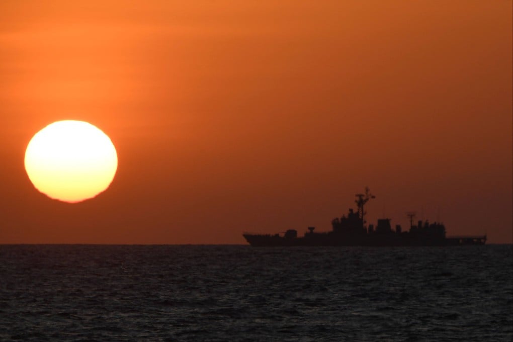 A Chinese warship is seen at sunrise near Scarborough Shoal in the disputed South China Sea late last month. Photo: AFP