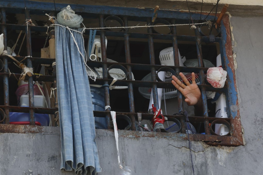 An inmate waves at the main prison in Haiti’s capital Port-au-Prince on Sunday. Photo: AP