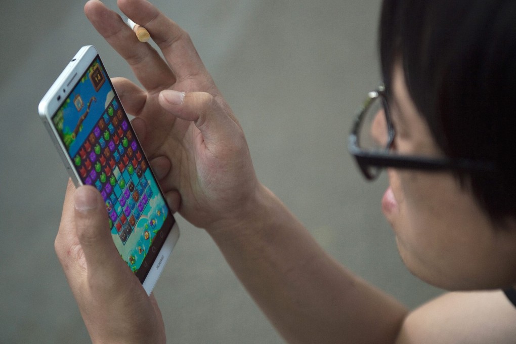 A Chinese man uses his smartphone to play a game. The name of the “live game” involved in the case was not disclosed. Photo: AFP