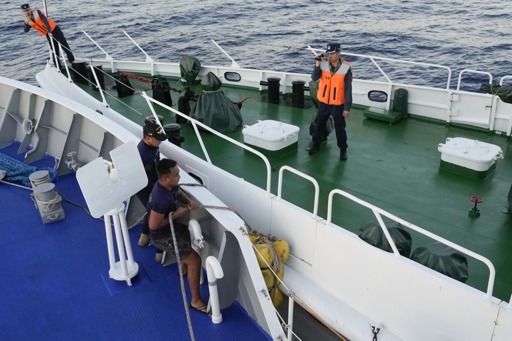 Philippine coast guard crew lower rubber fenders during a collision with a Chinese coast guard vessel (right). Photo: AP