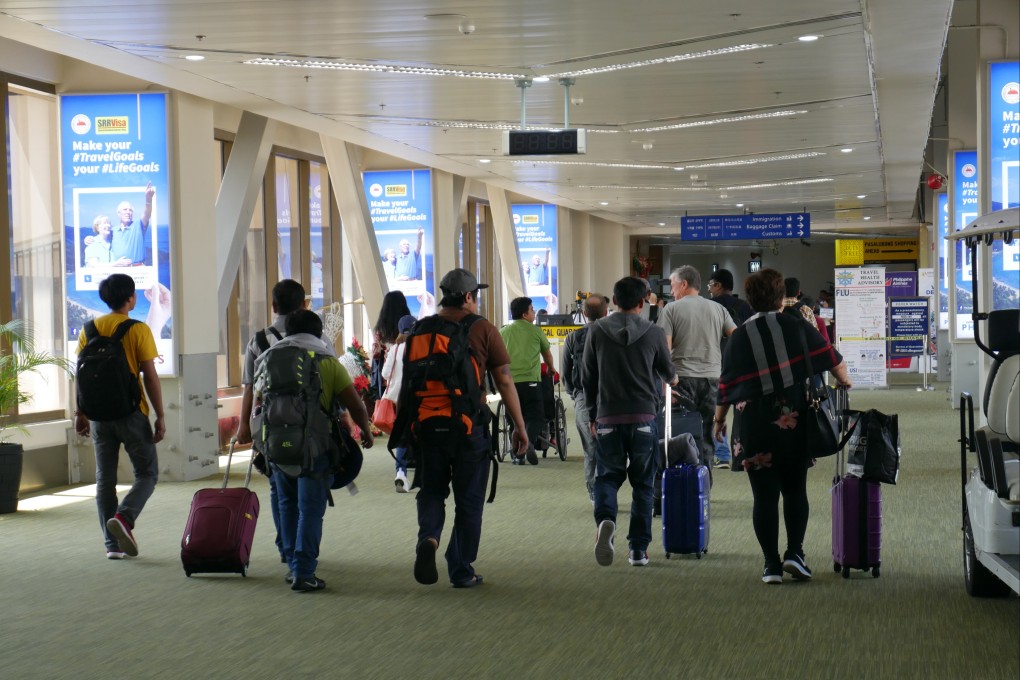 Travellers at Manila’s Ninoy Aquino International Airport. The Bureau of Immigration said a whole-of-government response was required to tackle the threat from foreigners entering the country using valid documents obtained through illicit ways. Photo: Shutterstock