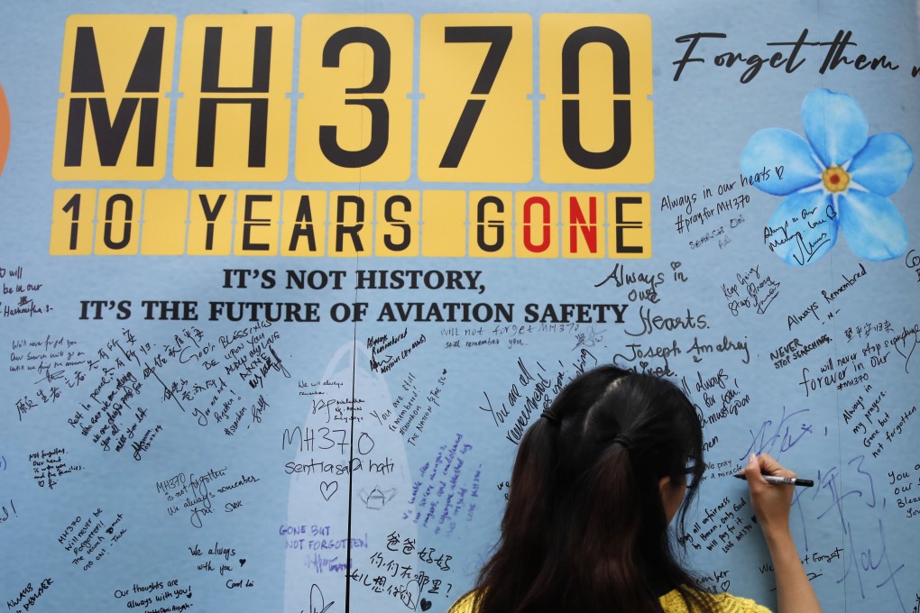 A woman writes on the message board during the 10th annual remembrance event of missing flight MH 370 at a mall in Subang Jaya, Malaysia on March 3, 2024. Photo: AP