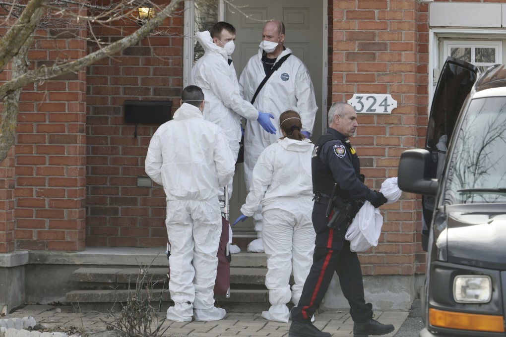 Members of the coroner’s office stand outside the scene of a homicide where six people were found dead in the Barrhaven suburb of Ottawa on Thursday. Photo: Canadian Press via AP
