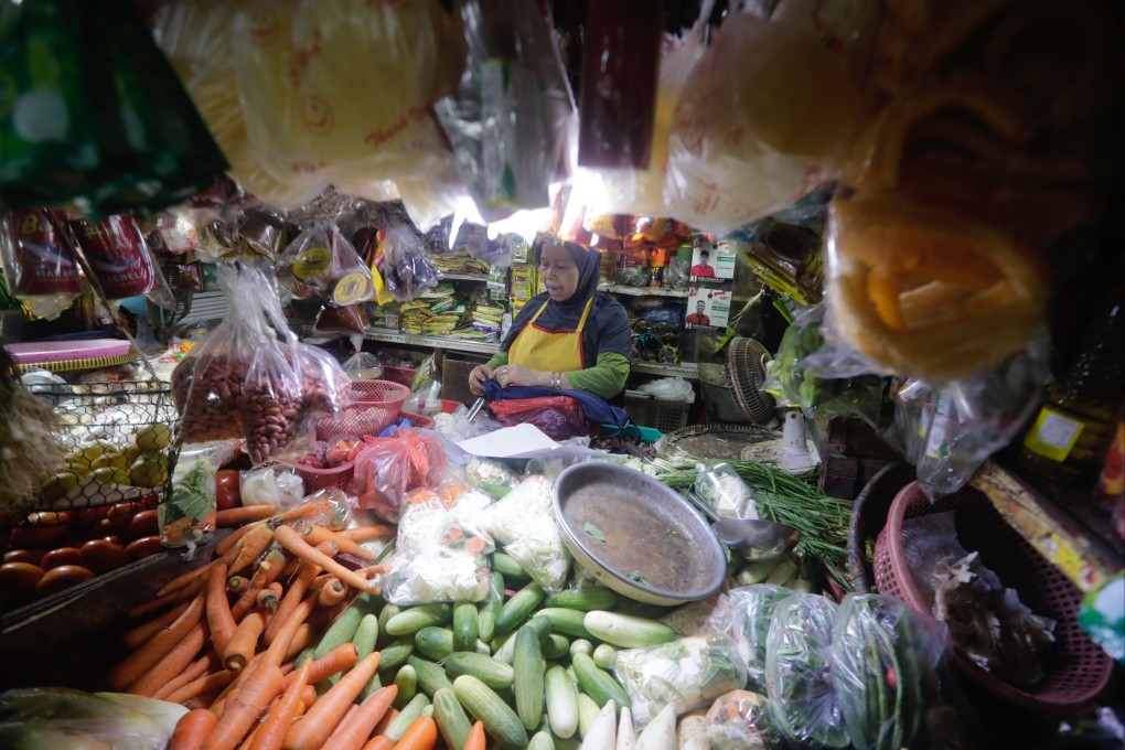 A food vendor waits for customers at a market in Depok on Wednesday. Indonesia is facing economic headwinds including high food inflation, a depreciating currency and declining commodities prices. Photo: EPA-EFE