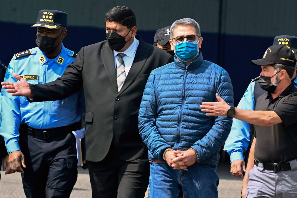 Former Honduras president Juan Orlando Hernandez (second from right) is escorted towards a plane for his extradition to the US at an air force base in Tegucigalpa in April 2022. Photo: AFP