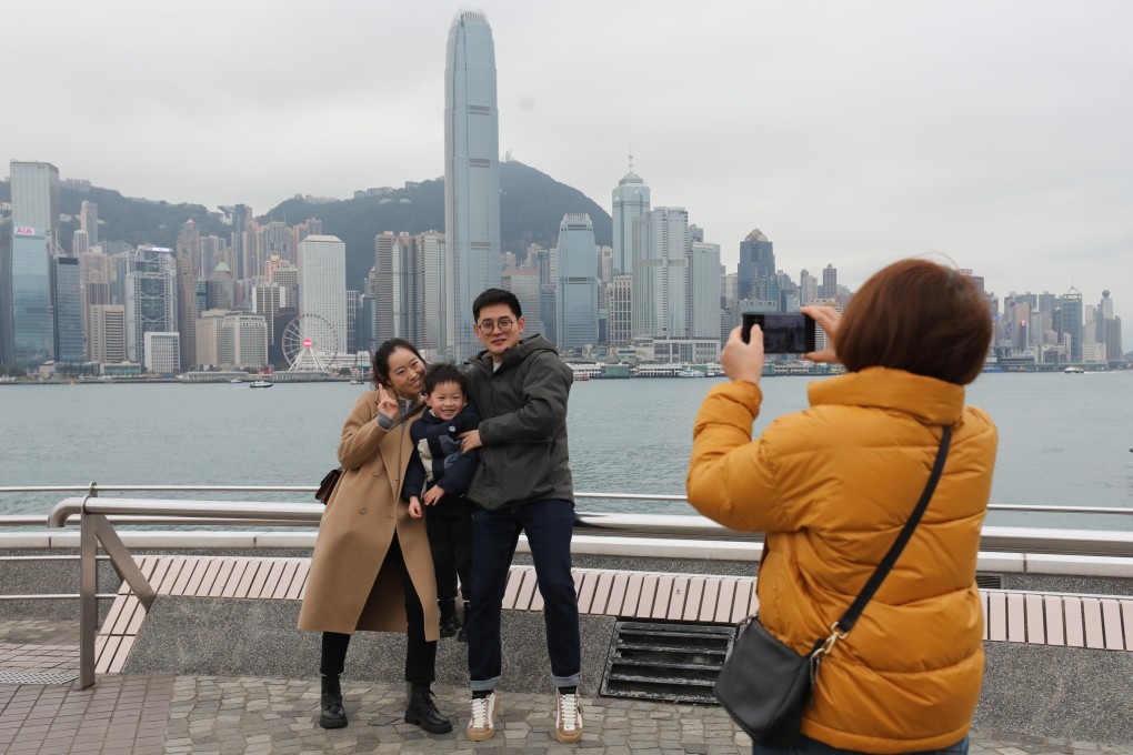 Tourists pose for photos at Victoria Harbour in Tsim Sha Tsui. Hong Kong will charge a three per cent hotel tax on January 1, 2025. Photo: Xiaomei Chen