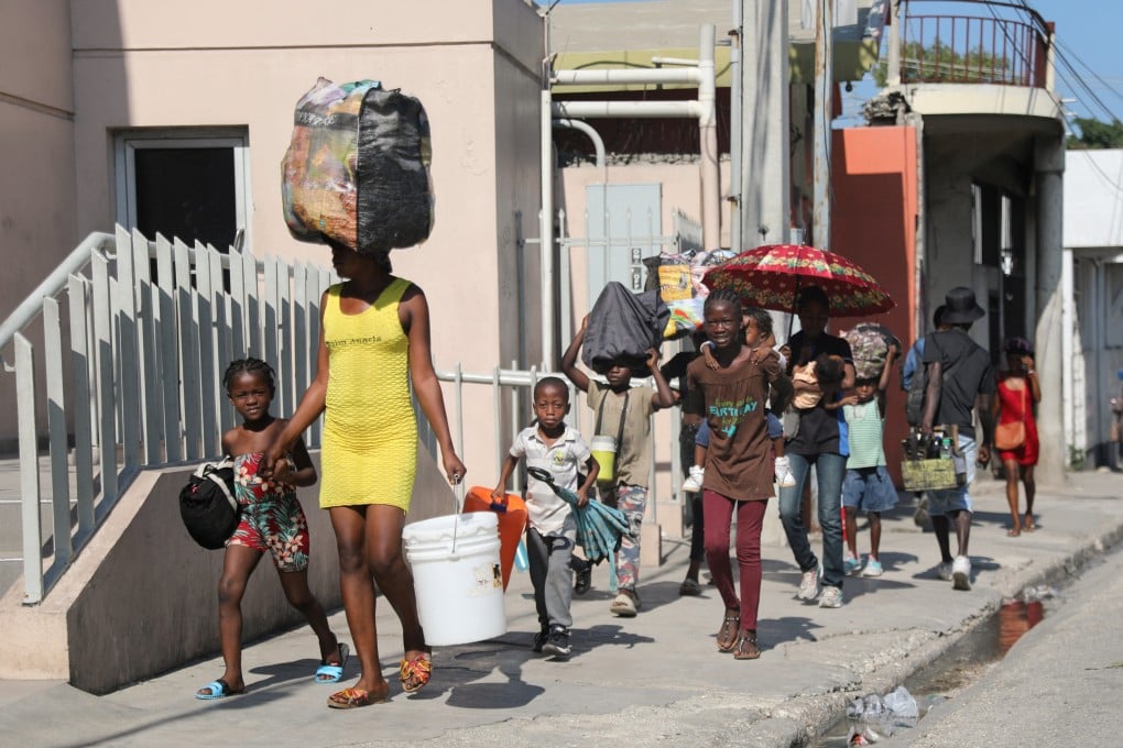 People flee with their belonging to a shelter in Port-au-Prince, Haiti, on Saturday. Photo: Reuters