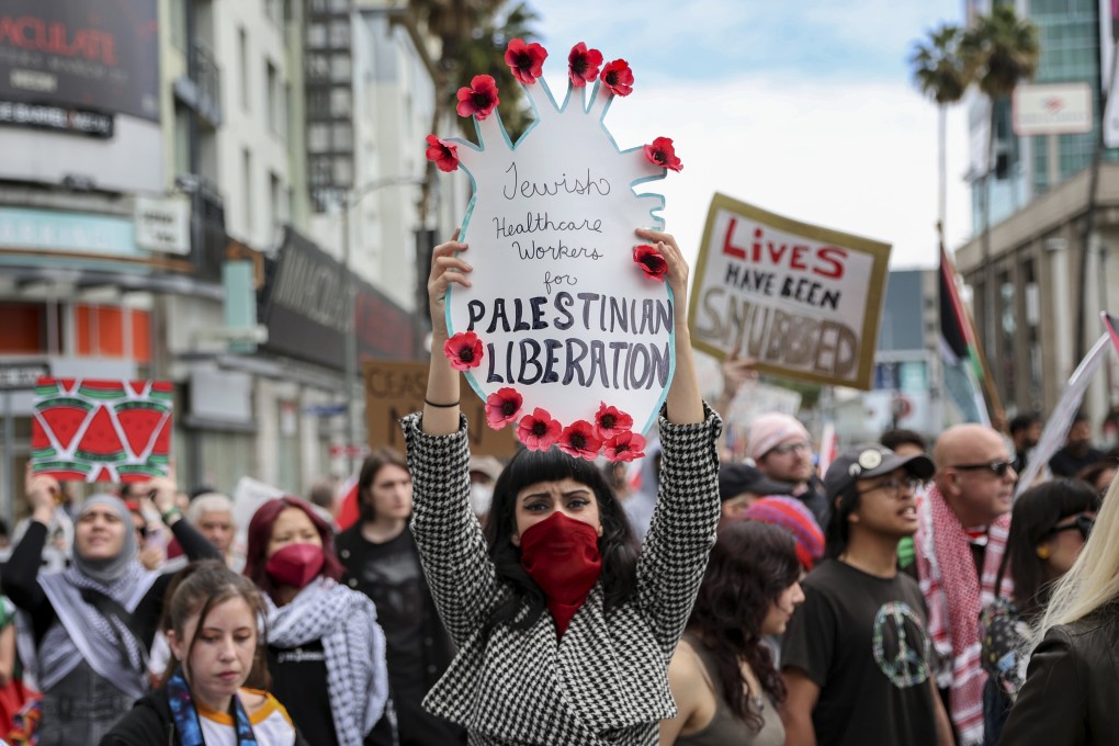 A protester in Hollywood, Los Angeles on Sunday holds a poster during a demonstration calling for a ceasefire in Gaza as the Oscars ceremony is held nearby. Photo: AP