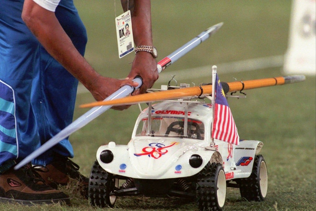 A track marshall clips javelins onto a remote control car during the decathlon event at the 16th Commonwealth Games in Kuala Lumpur, Malaysia, in 1998. Photo: AP