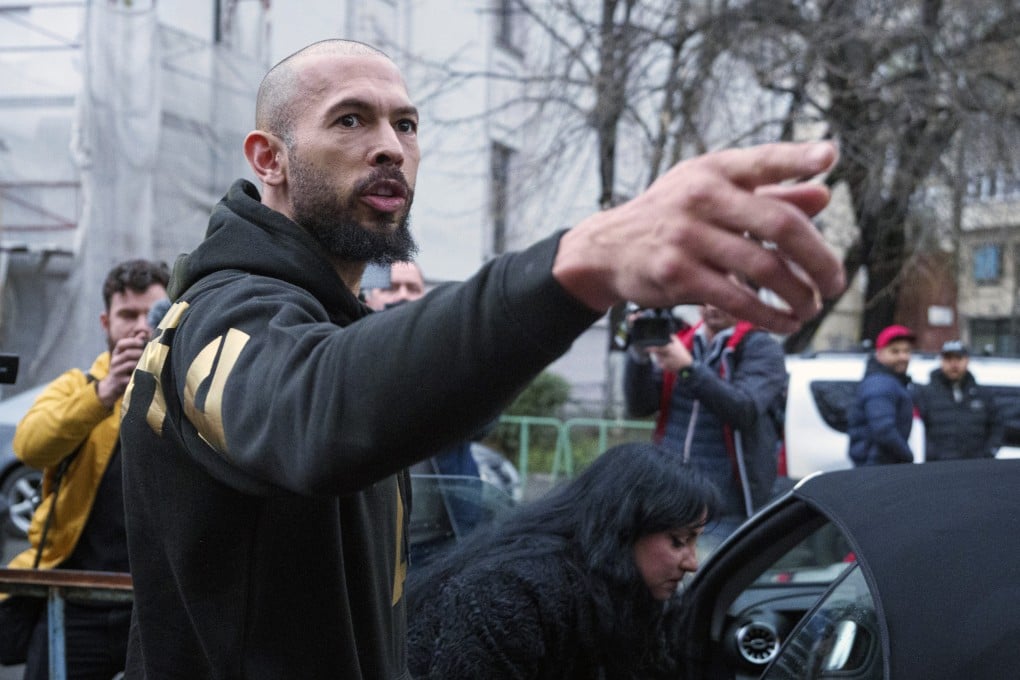 Andrew Tate gestures upon exiting a police detention facility in Bucharest, Romania, on Tuesday. Photo: AP