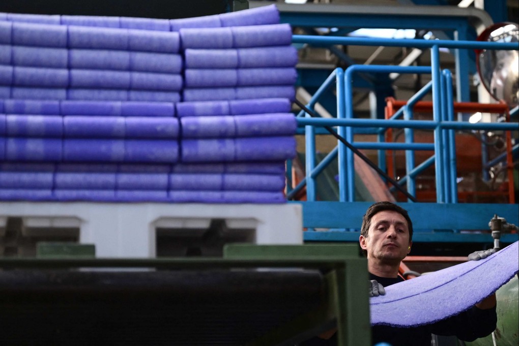 A Mondo employee works on the production of the the Paris 2024 Olympics and Paralympic Games’ athletics track at the Mondo Group production and R&D laboratories in Alba, northwestern Italy. Photo: AFP