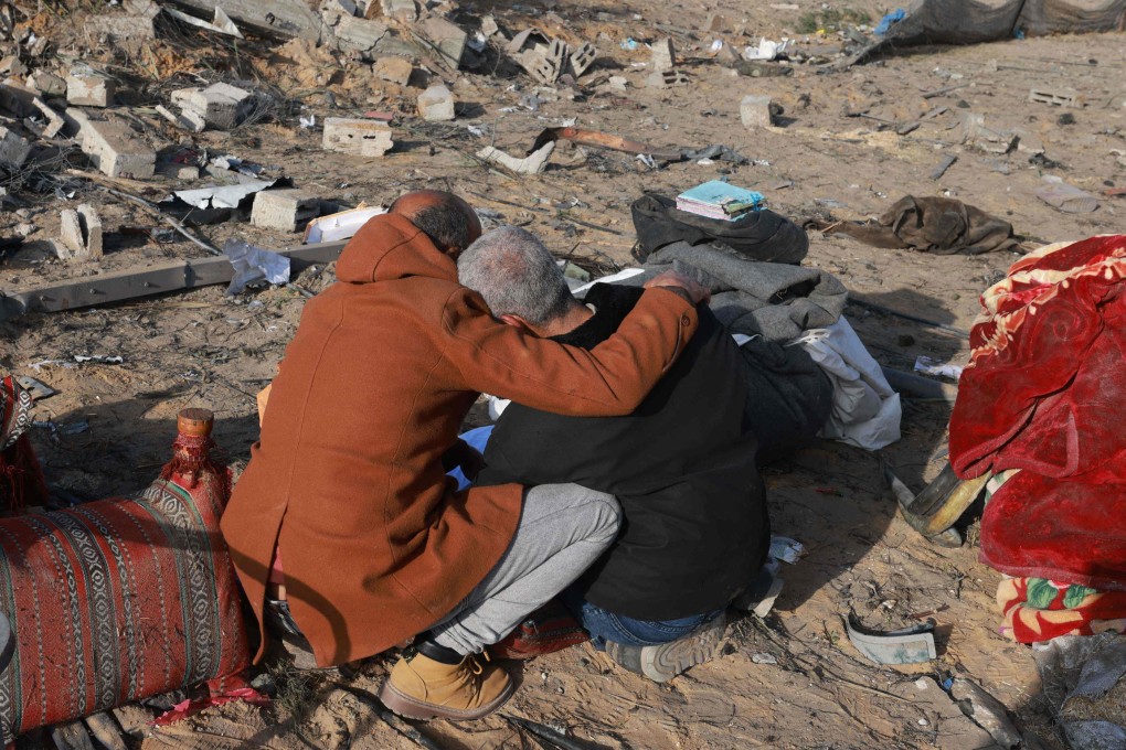 A Palestinian man comforts another as they inspect the destruction in Rafah. Photo: AFP