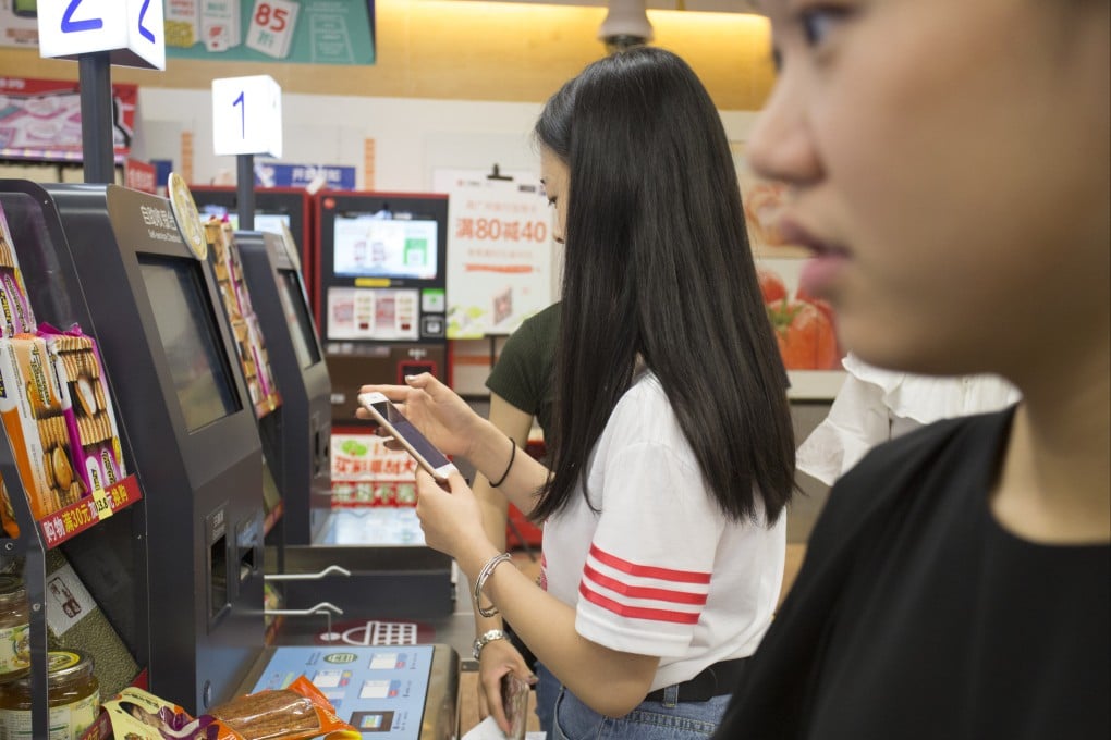 Customers use their mobile phones to make a payment at a ParkNShop store in Shenzhen in August 2017. Photo: May Tse