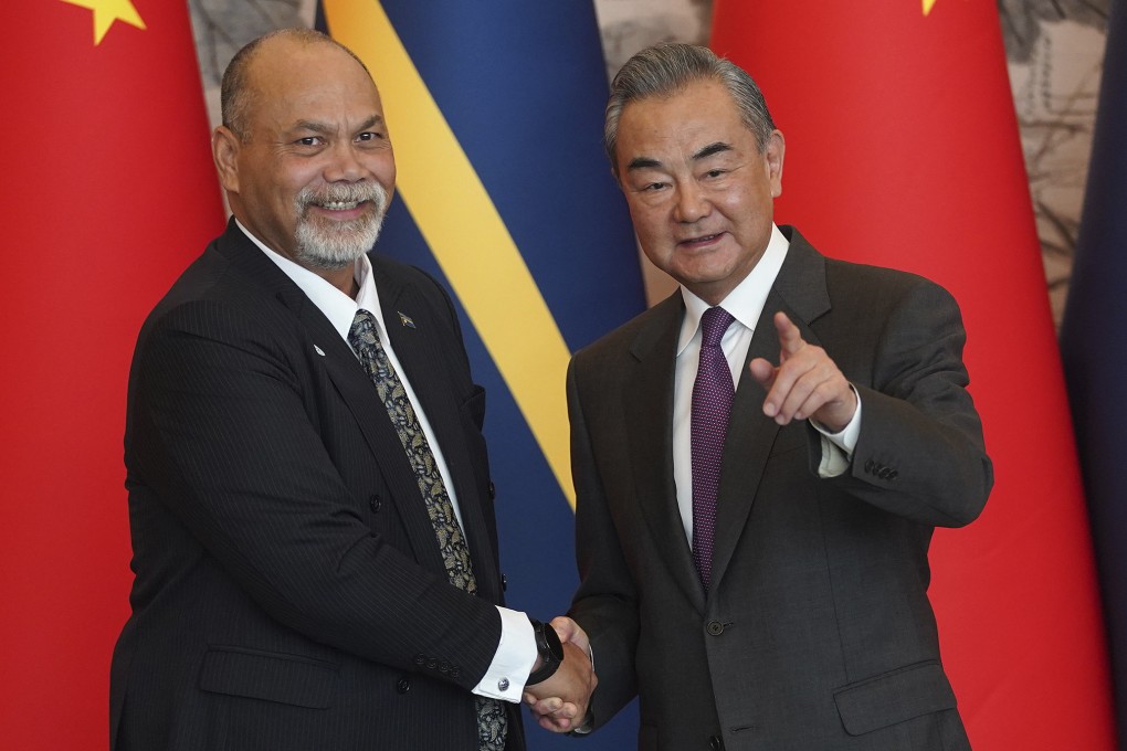 Chinese Foreign Minister Wang Yi (right) and his Nauru counterpart Lionel Aingimea shake hands after signing the joint communique on the resumption of diplomatic relations between China and Nauru in Beijing on January 24. Photo: AP