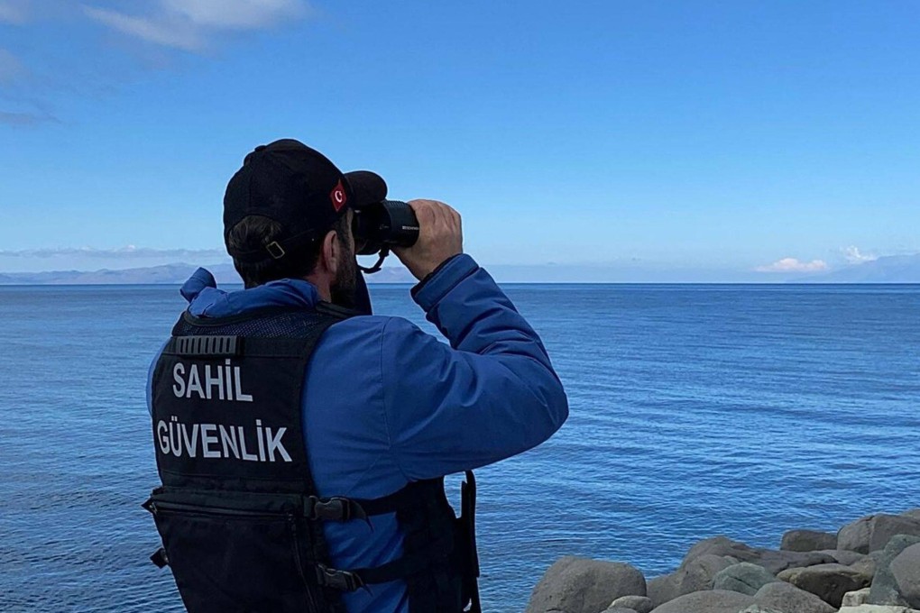 A coast guard officer looks for victims, after migrants drowned after a boat carrying them capsized off the Turkish coast in the Aegean Sea. Photo: DHA/AFP