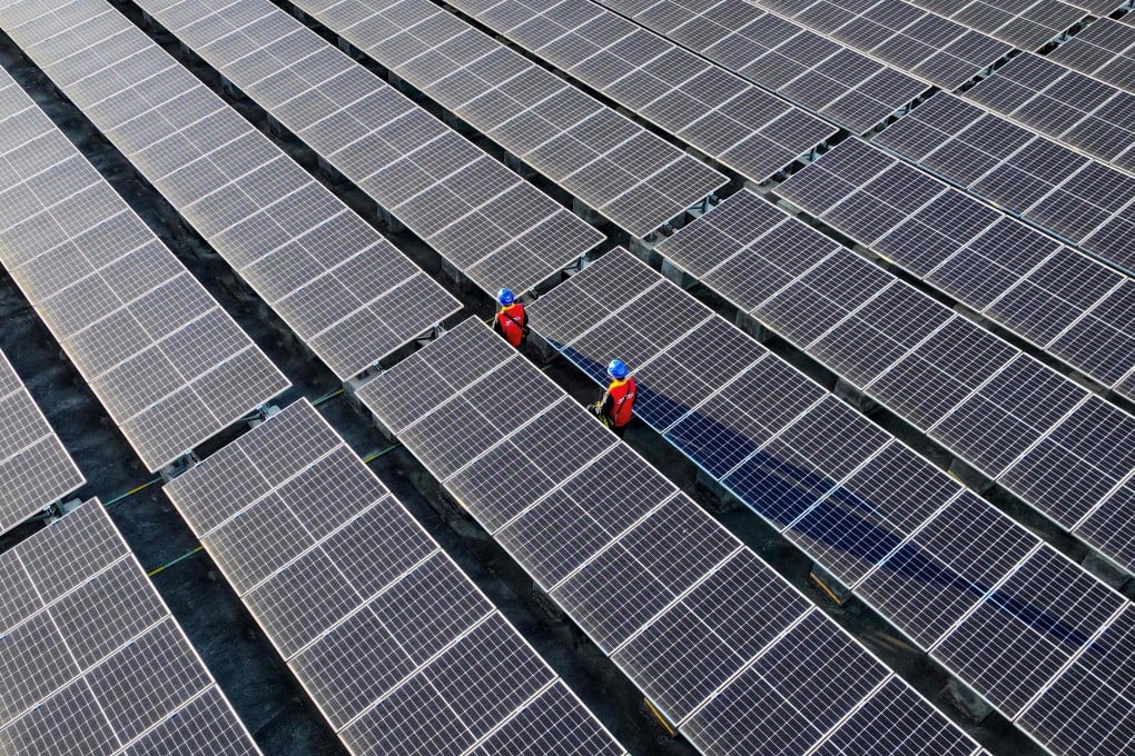 Workers inspect solar panels on the rooftop of a power plant in China’s Fujian province. Photo: AFP