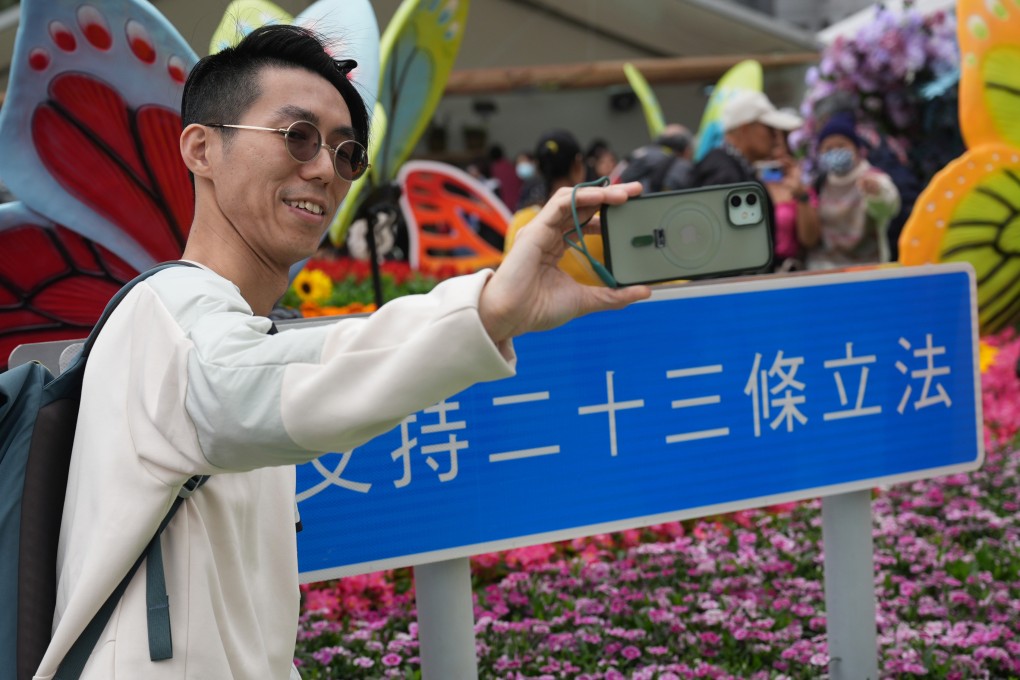 Visitors take selfies in front of a sign supporting the legislation of article 23. Photo: Eugene Lee