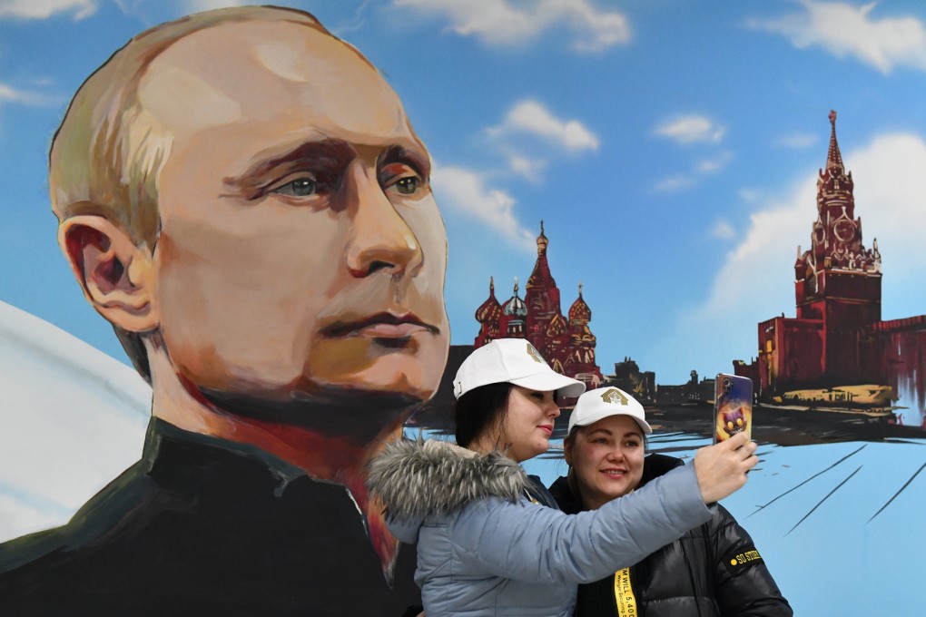 Women pose in front of a portrait of Russian President Vladimir Putin after voting at a polling station in Donetsk, in the Russian-controlled part of Ukraine, on Friday. Photo: EPA-EFE