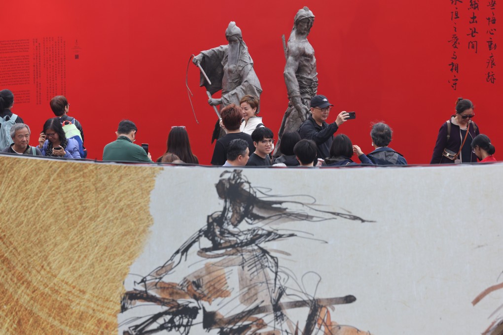 Visitors attend the Jin Yong exhibition at Edinburgh Place in Central on Saturday. Photo: Yik Yeung-man