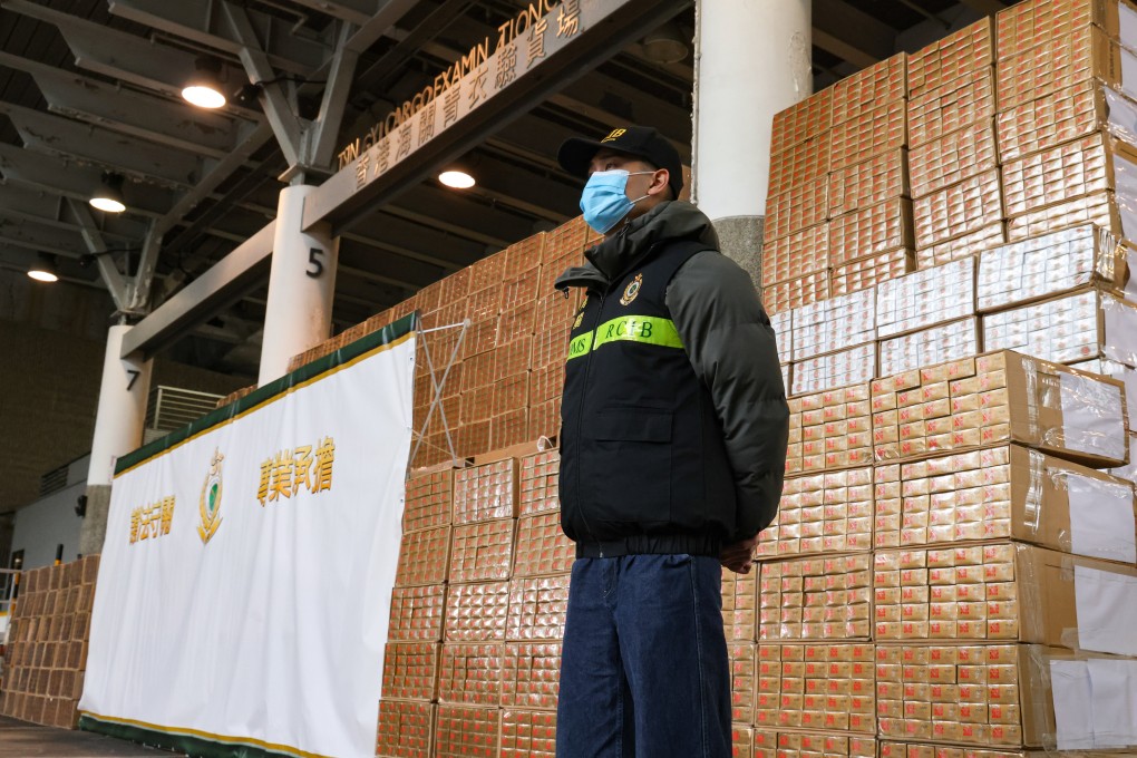 A customs officer stands guard over some of the millions of dollars worth of contraband cigarettes seized as part of the post-budget crackdown on contraband tobacco. Photo: Dickson Lee