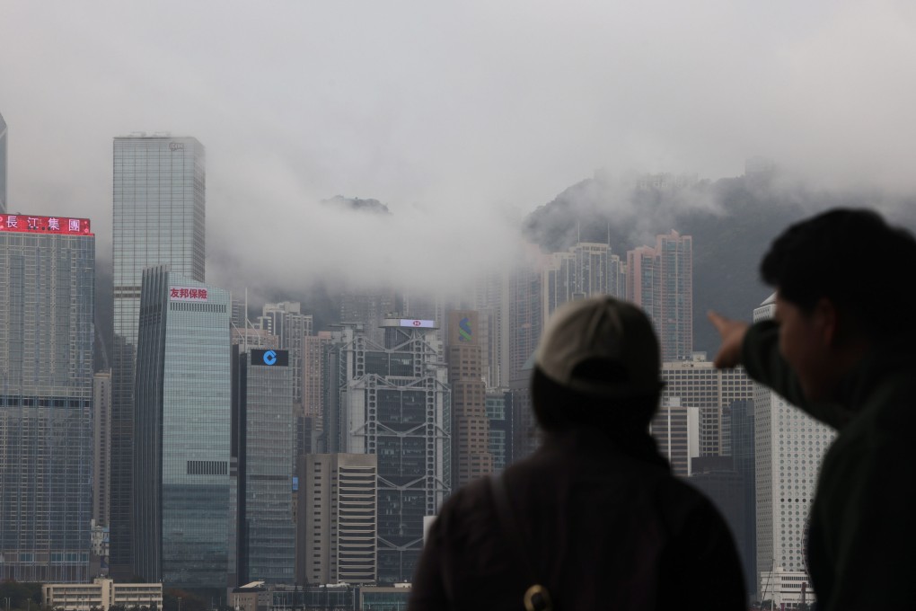 People on the Tsim Sha Tsui waterfront point to fog covering Hong Kong’s iconic skyline on March 11. Photo: Jelly Tse