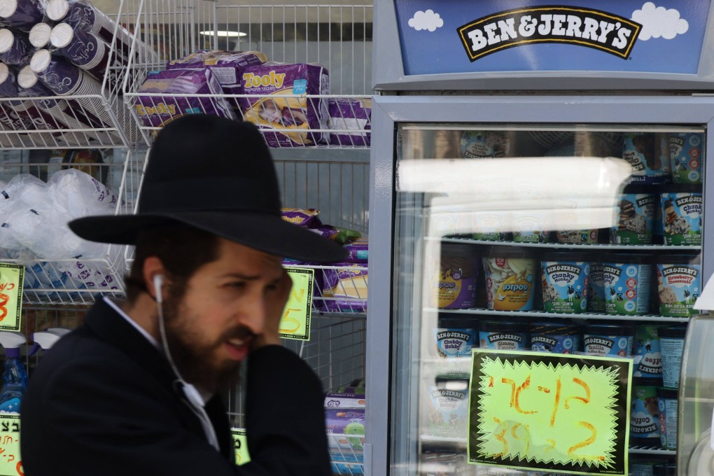 An Ultra Orthodox Jewish man walks by Ben & Jerry’s ice cream in Jerusalem. Ben & Jerry’s owner Unilever will spin off its ice cream arm, and cut 7,500 jobs globally. Photo: AFP