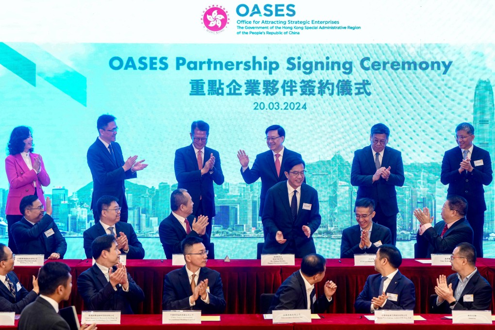 Chief Executive John Lee (back row, third from right) attends the signing ceremony. The government’s Office for Attracting Strategic Enterprises has met at least 200 firms so far. Photo: Sam Tsang