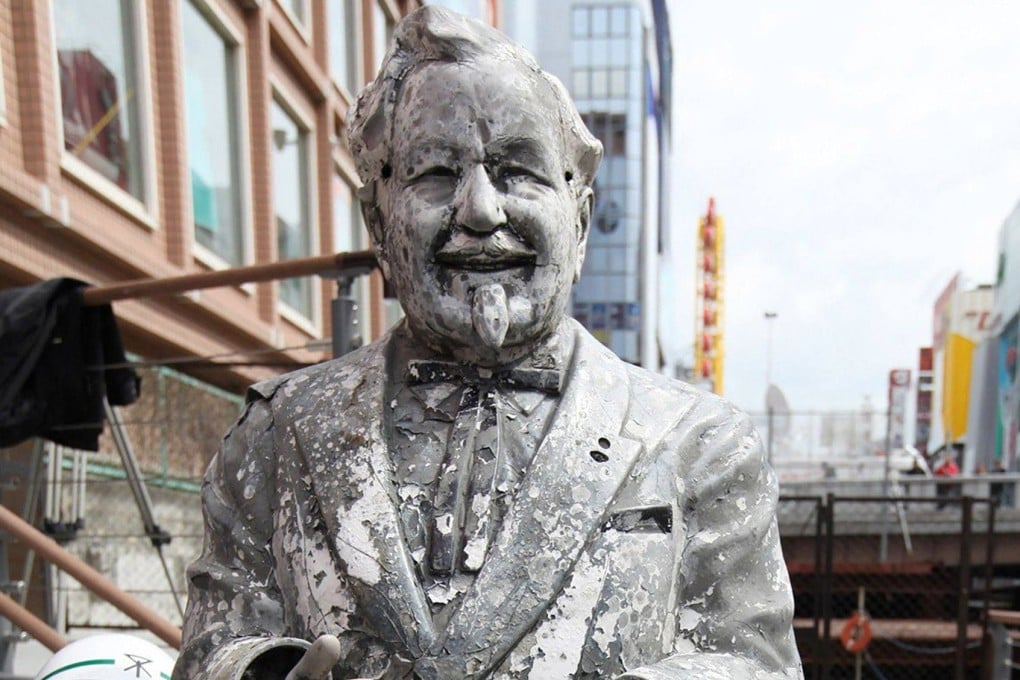A statue of KFC’s Colonel Sanders is displayed by Osaka city officers on March 11, 2009. It was recovered nearly a quarter of a century after fans of Hanshin Tigers threw it into a river. Photo: AFP