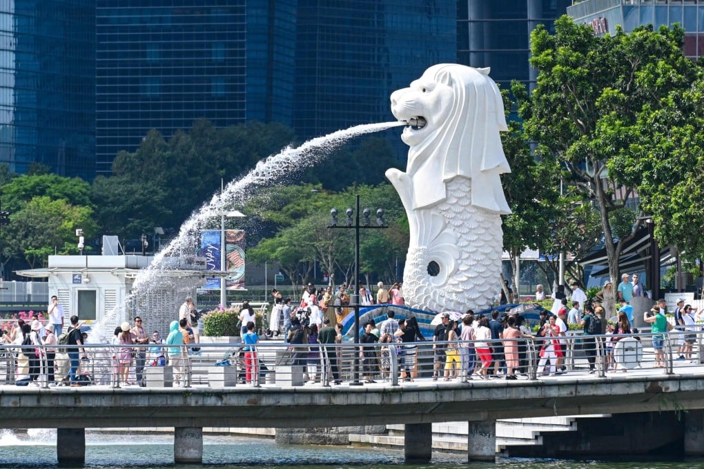 Tourists gather for photos near the Merlion statue in Singapore. More than 327,000 people arrived in the city state from China last month, official figures show. Photo: AFP