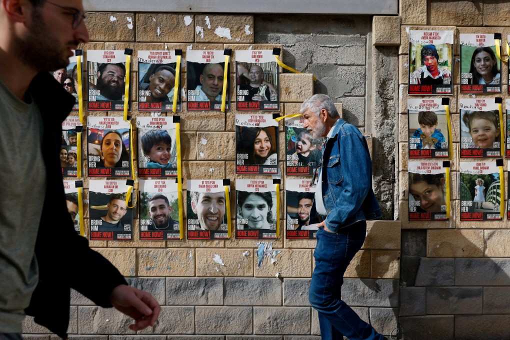 People walk past placards with photos of hostages kidnapped in the deadly October 7 attack on Israel by Hamas from Gaza, in Tel Aviv, Israel, on March 17. Photo: Reuters